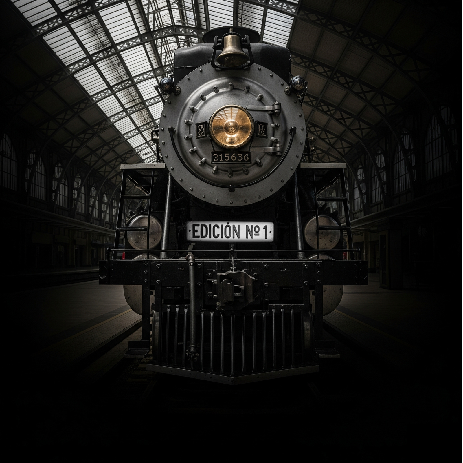 Fotografía de una locomotora antigua de frente, en una estación. Tiene una placa que deice Edicòn Nº 1