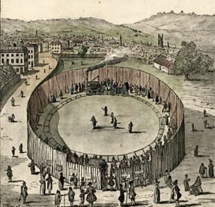 Catch Me Who Can, Londres, 1808 A colored historical engraving of Richard Trevithick's "Steam Circus" in London, 1808. A high wooden fence forms a circular enclosure where the "Catch Me Who Can" steam locomotive pulls a carriage along a circular track. A crowd of people in period clothing watches the demonstration from outside the fence and inside the arena, with the cityscape of Bloomsbury and rolling hills visible in the background.